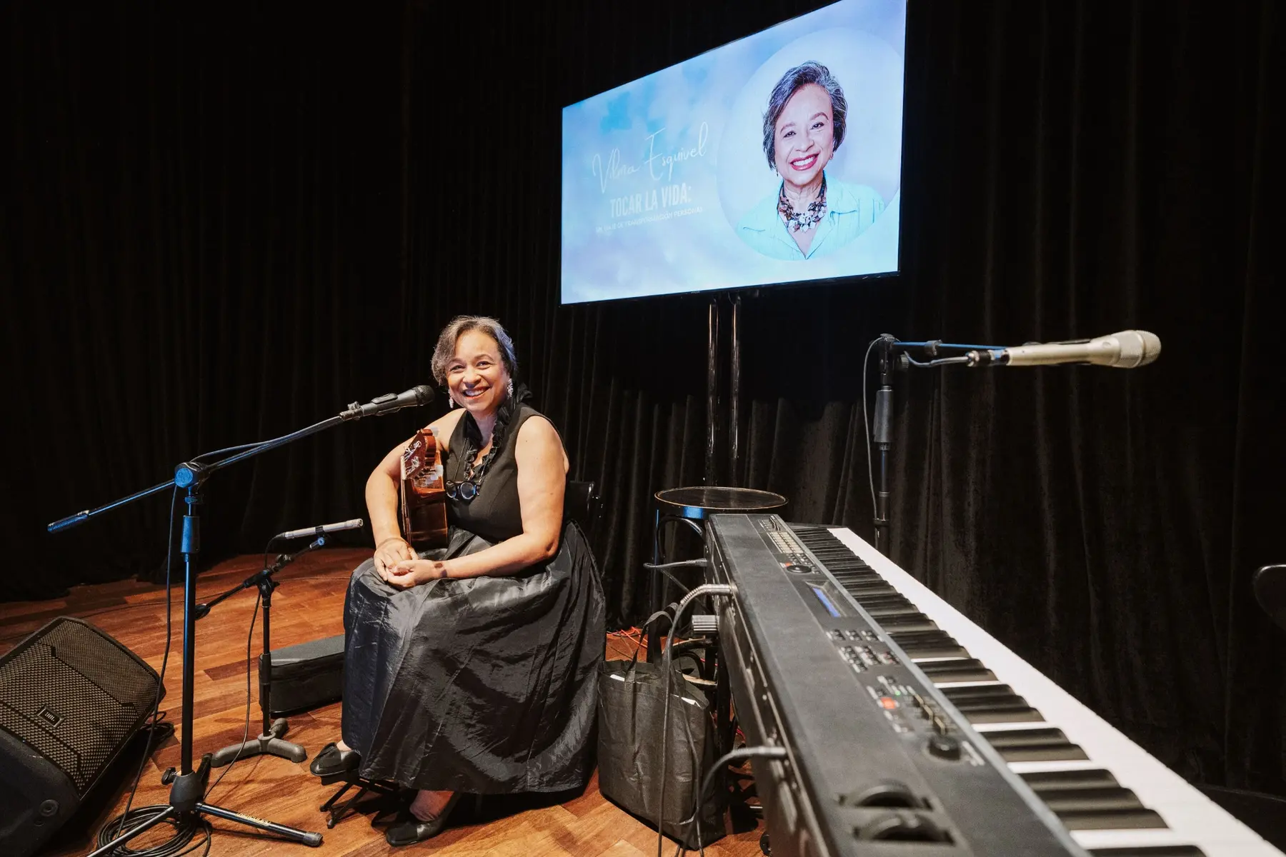 Vilma Esquivel between the guitar and piano during a musical performance